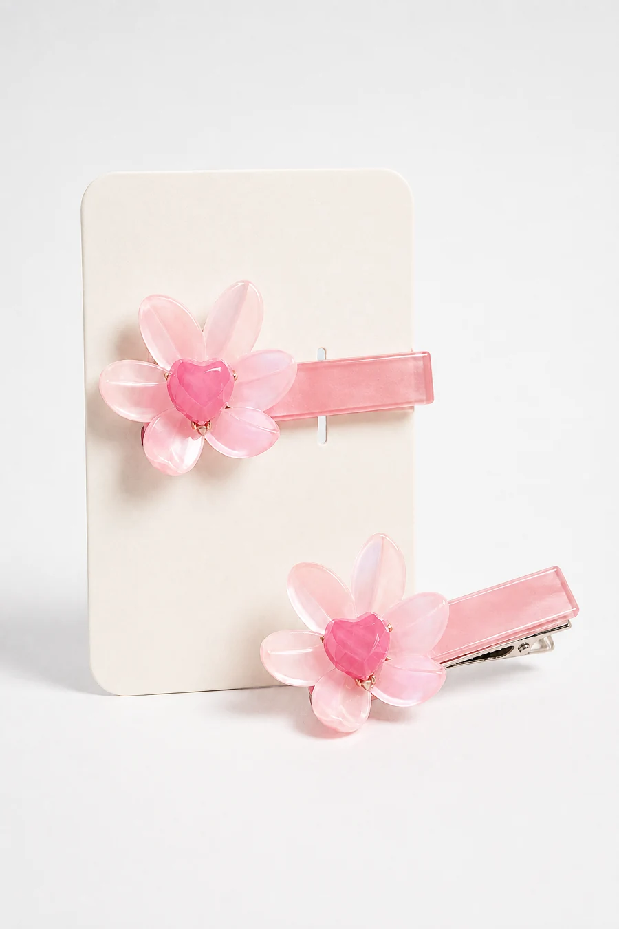 Pink flower hair clips on a cream packaging card