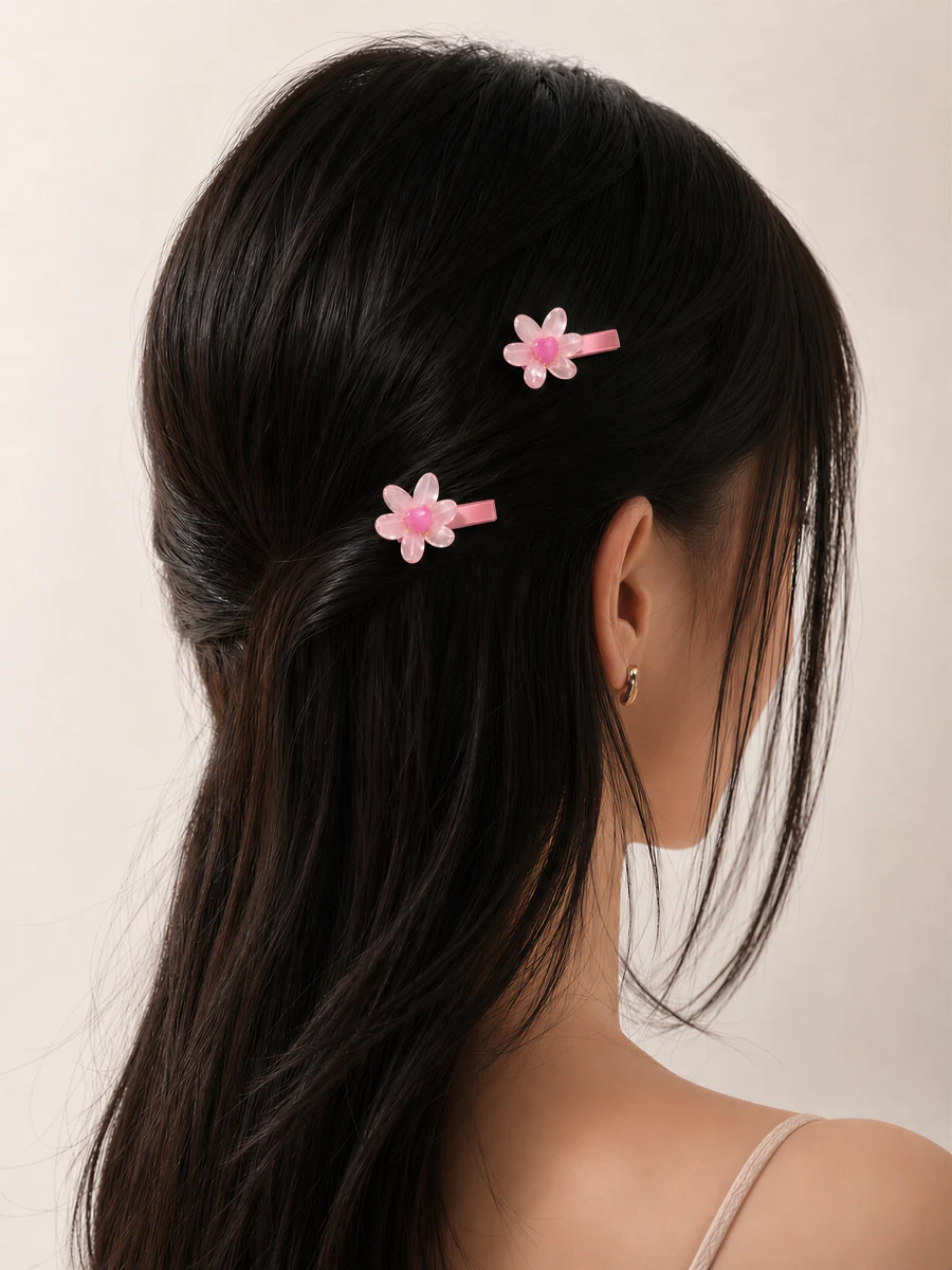 Two pink flower clips styled in dark hair