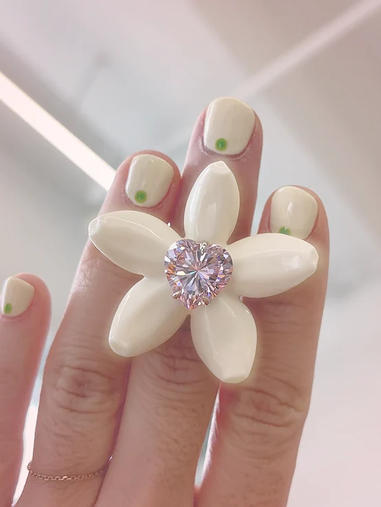 Supplied close-up photograph of a cream flower accessory with a sparkling center